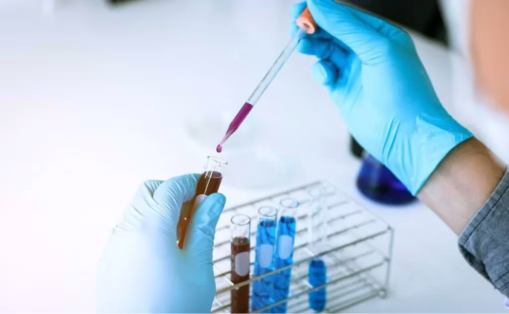 scientist dropping liquid in a pipette