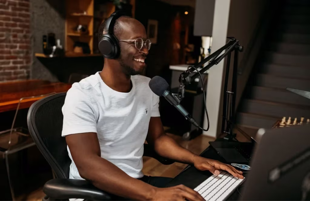 man in on a podcast with headphones and a microphone